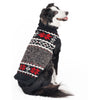 Dog wearing a black and gray patterned sweater on a white background