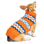 Dog wearing an orange sweater with a white and blue pattern on a white background