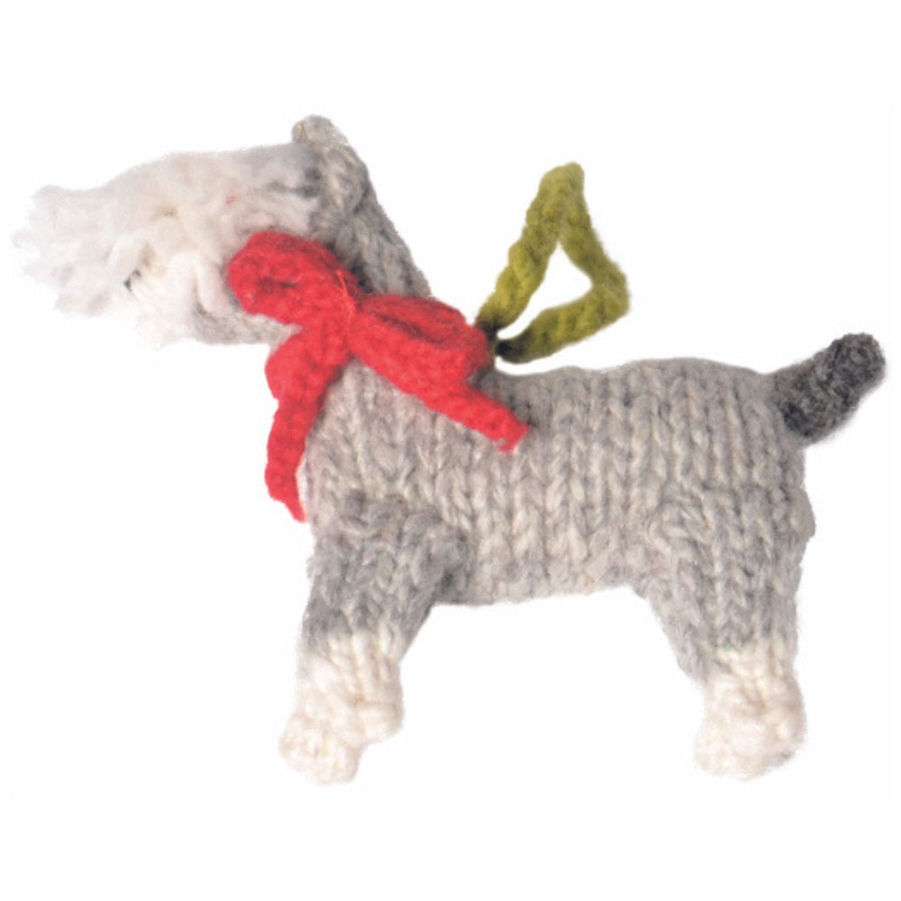 Knitted dog toy with a red bow and green bell on a white background