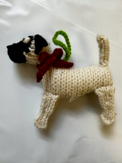 Knitted dog ornament with a bow on a white background