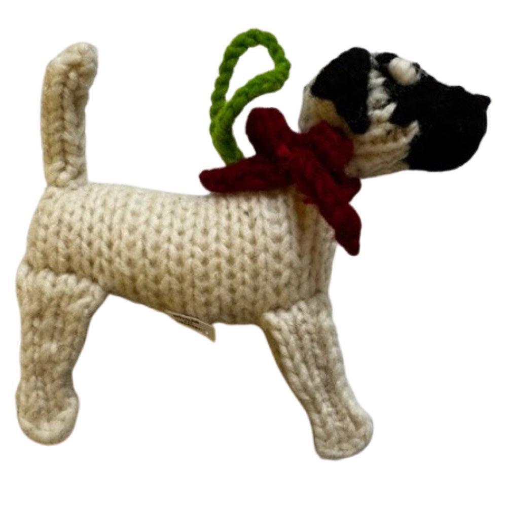 Knitted dog toy with a red bow and green tag on a white background