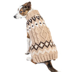 Dog wearing a beige knitted sweater with a pattern on a white background